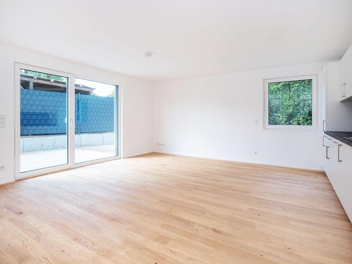 Neubau-Gartenwohnung, 2 Zimmer, bezugsfertig & provisionsfrei, KfW 40 QNG | Parsdorf bei München – Wohnzimmer mit Terrasse