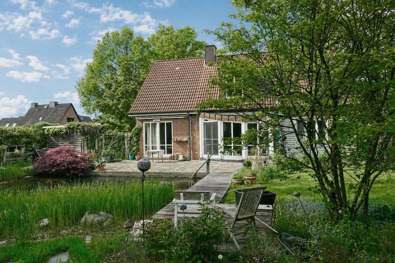 Lichtdurchflutetes Architektenhaus mit Schwimmteich – Gartenansicht