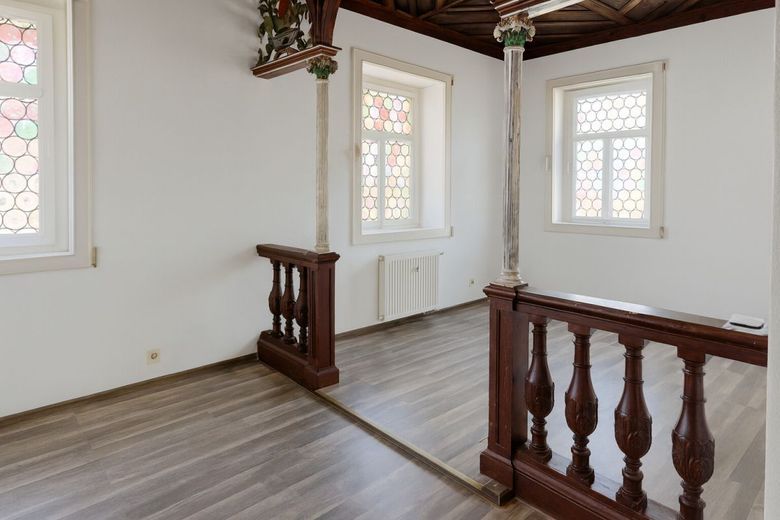 Stilvolle Galerie im Wohnzimmer mit antiken Säulen und kunstvoll gearbeiteter Holzbalustrade