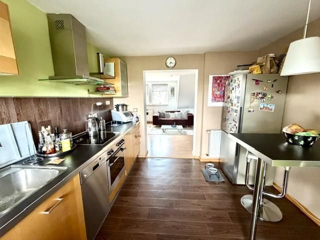Helle Dachgeschosswohnung mit Loggia und Einbauküche – Küche mit Blick ins Wohnzimmer