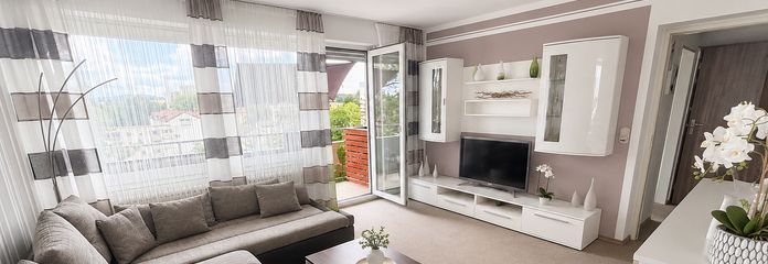 Vermietete 2-Zimmer-Wohnung mit Weitblick, Aufzug und Balkon – Kapitalanlage in Traunreut – Wohnzimmer mit Balkonzugang