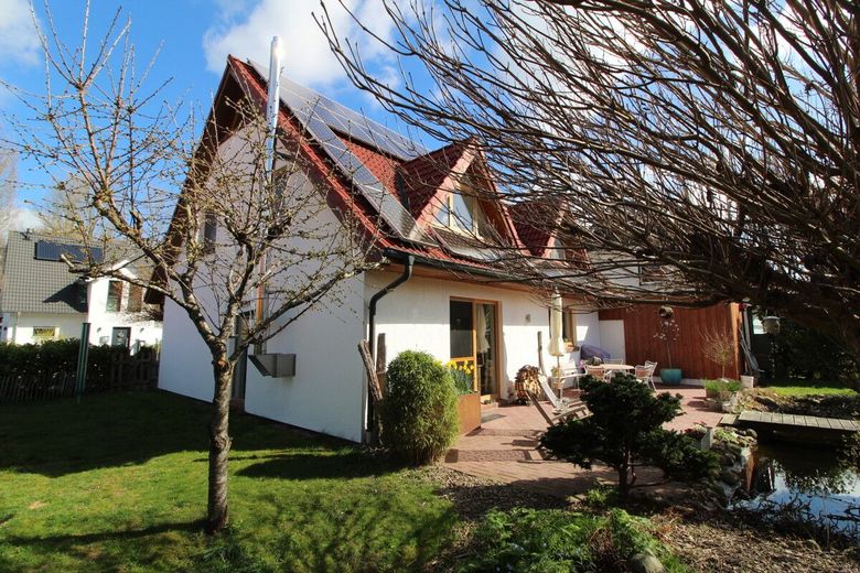 Exquisites Einfamilienhaus in neuwertigem Zustand mit PV-Anlage,Carport und idyllischer Gartenanlage – Giebelansicht mit Terrasse