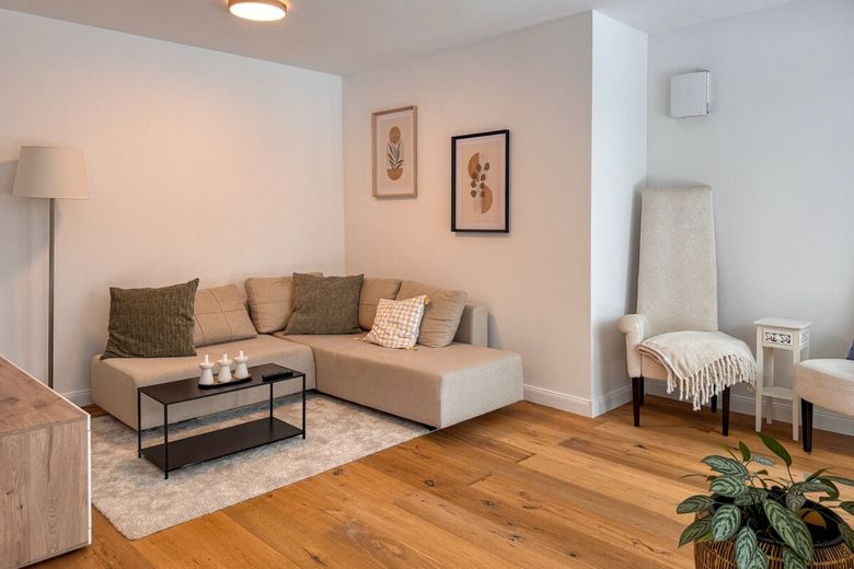 Wohnen wie im Haus: Ebenerdig 3 Zimmer mit Garten u. Tiefgarage am Bürgerpark im Neubau von 2023 – Wohnzimmer