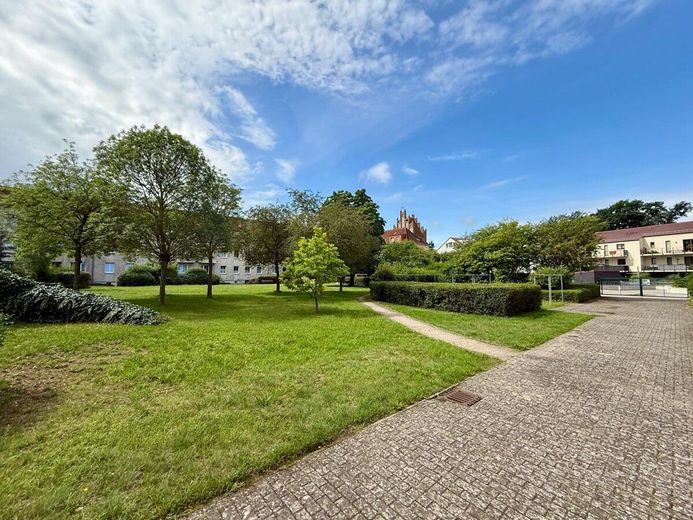 HORN IMMOBILIEN++RESERVIERT! Neubrandenburg Zentrum, helle 3-Raum Eigentumswohnung, EBK, Keller &amp; Parkfläche – Innenhof im Frühling/Sommer