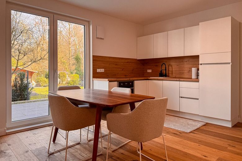 Wohnen wie im Haus: Ebenerdig 3 Zimmer mit Garten u. Tiefgarage am Bürgerpark im Neubau von 2023 – Essbereich mit Küche