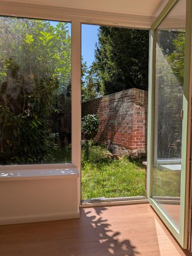 Wyjątkowe mieszkanie 1,5-pokojowe z działką ogrodową przy murach miejskich w centrum Greifswaldu – Wohnzimmer mit Gartenzugang