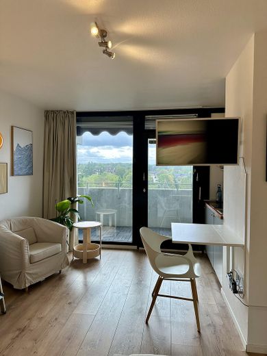 VANAF AUG 2027: Stijlvol gemeubileerd appartement | Tijdelijk wonen | Gemeubileerd wonen in Sachsenhausen – Wohnbereich mit Fernseher