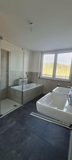1. piętro nowoczesne mieszkanie 3,5-pokojowe z windą, zabudowaną kuchnią, zadaszonym balkonem, pomieszczeniem gospodarczym i WC dla gości – Bad