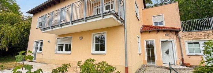 Einfamilienhaus am Hang mit Panorama und angrenzenden Waldgrundstücken.
