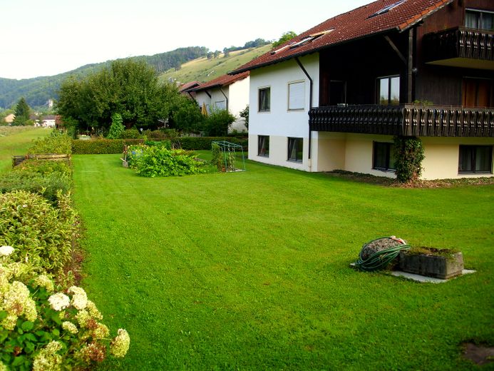 Günstige 4,5-Zimmer-Wohnung mit Balkon, Garten und Wärmepumpe in Obereichstätt zu vermieten – Hausansicht mit Garten