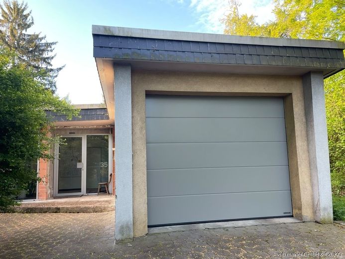 Rarität im Fichtelgebirge: Kernsanierter Bauhaus-Bungalow mit 163m² auf 7.500 m² Parkgrundstück – 07_Garage-Sektionaltor-Hauseingang