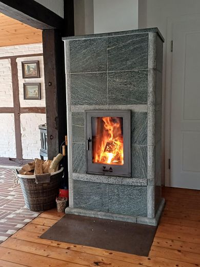 Da privato: casa storica modernizzata con tetto di paglia in posizione idilliaca – Specksteinofen im Wohnzimmer
