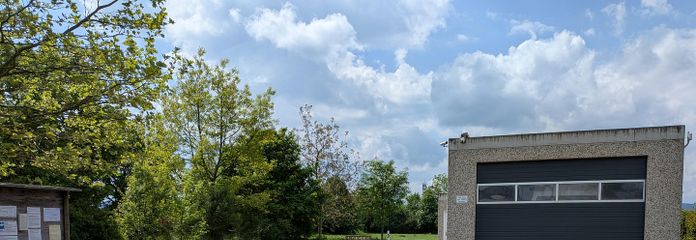 Bedrijfsterrein (splitsing mogelijk) met grote garages en woonmogelijkheid aan de rand van het veld – Ansicht von der Straße
