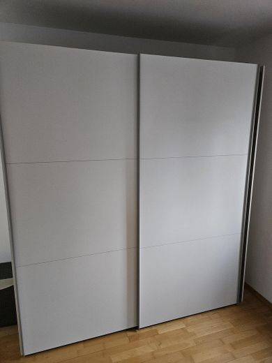 Appartamento arredato di 2 locali con balcone, posto auto TG e WLAN – ideale per expat – Kleiderschrank in Schlafzimmer