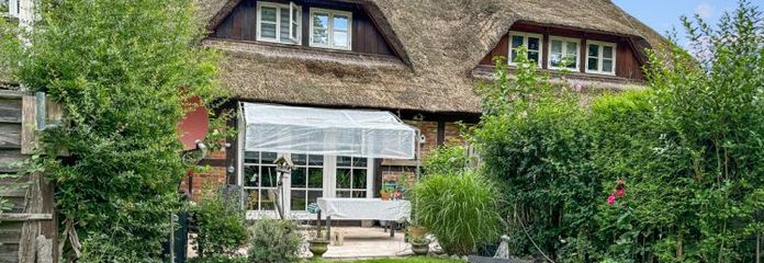 Thatched mid-terrace house with a large garden and garage