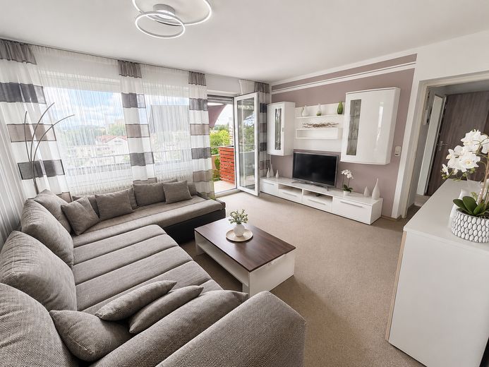 Vermietete 2-Zimmer-Wohnung mit Weitblick, Aufzug und Balkon – Kapitalanlage in Traunreut – Wohnzimmer mit Balkonzugang