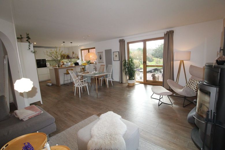 Exquisites Einfamilienhaus in neuwertigem Zustand mit PV-Anlage,Carport und idyllischer Gartenanlage – Wohnzimmer mit Zugang Terrasse