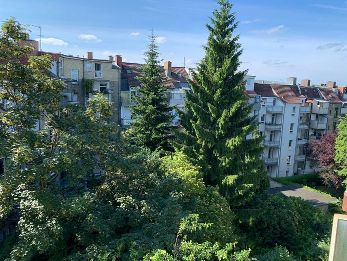 Helle, schöne und gepflegte Altbauwohnung mit Dielenfussboden und Einbauküche – Blick aus der Loggia 