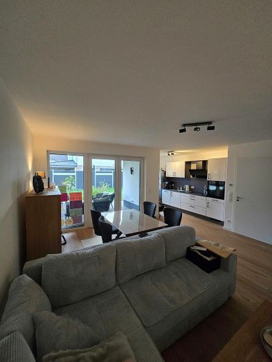 Stillvolle 4-Zimmer EG Neubauwohnung KFW 40 (Wärmep.+PV) mit Terrasse, Garten, Parkplatz – Wohnzimmer/offene Küche