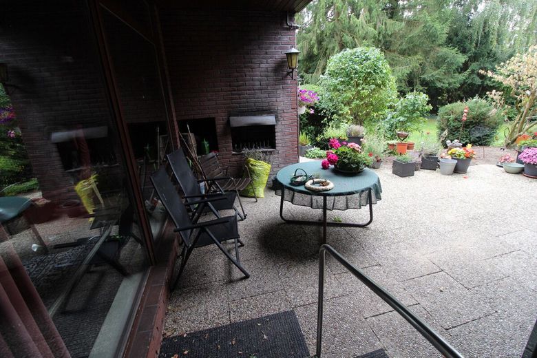 Individueller Flachdach-Bungalow mit Doppelgarage &amp; Parkähnlichem Grundstück in Schiffdorf-Sellstedt – 16 - überdachte Terrasse mit Außenkamin