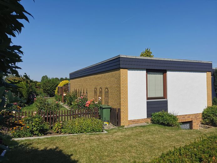 Gepflegter Bungalow mit parkähnlichem Garten – Blick vom Fußweg