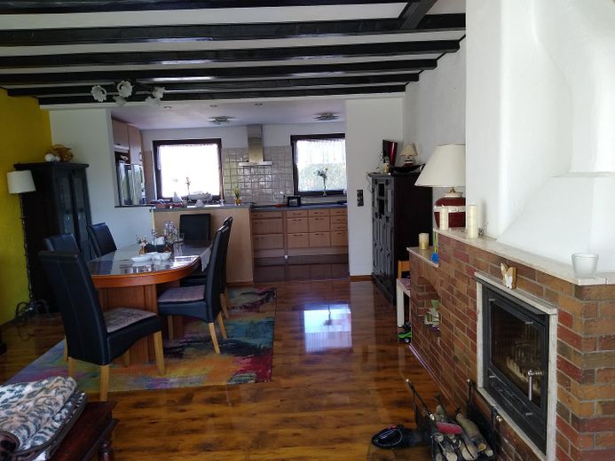 Wohnzimmer mit Kamin und Küche