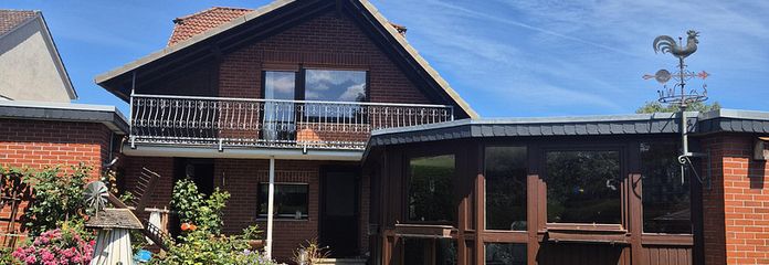 Charmantes Einfamilienhaus mit traumhaftem Südgarten, Wintergarten und Doppelgarage – Rückansicht Haus