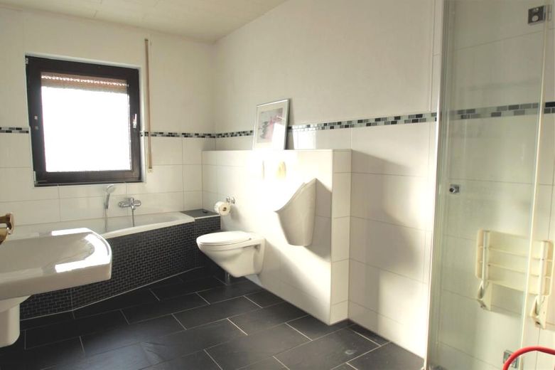 CITYHOUSE: Freistehendes Einfamilienhaus mit großem Grundstück, Kamin, Doppel- und Einzelgarage – Modernes Badezimmer