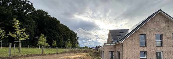 Hochwertige 3-Zimmer-Gartenwohnung mit Südterrasse, Designküche & Blick ins Grüne – Hausansicht mit Grünblick