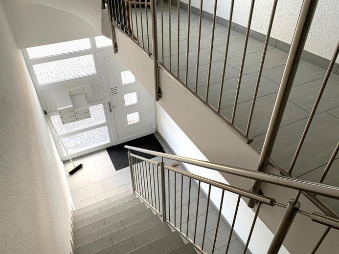 Jasne, w dużej mierze bezbarierowe mieszkanie własnościowe z balkonem i windą – Treppenhaus Blick zum Eingang
