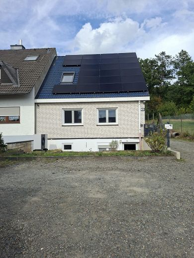 Modernisiertes Einfamilienhaus mit Wärmepumpe, großer PV-Anlage und großzügigem Grundstück – Frontansicht mit Stellplätzen