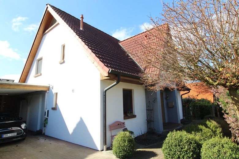 Exquisites Einfamilienhaus in neuwertigem Zustand mit PV-Anlage,Carport und idyllischer Gartenanlage – Hauseingang und Giebelansicht
