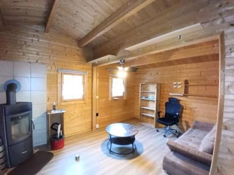 Ruhig, sicher und abseits von einer Stadt: Holzhaus Luxuslage im Wald eingebettet zwischen 3 Seen – Wohnzimmer mit Kamin