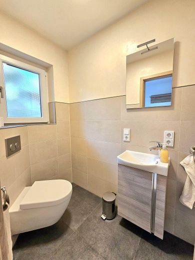Moderne 3,5 Zimmer EG Wohnung 155 m² Wohnfläche + 190 m² Nutzfläche mit Balkonen & Terrasse & Garten – Modernes Gäste-WC