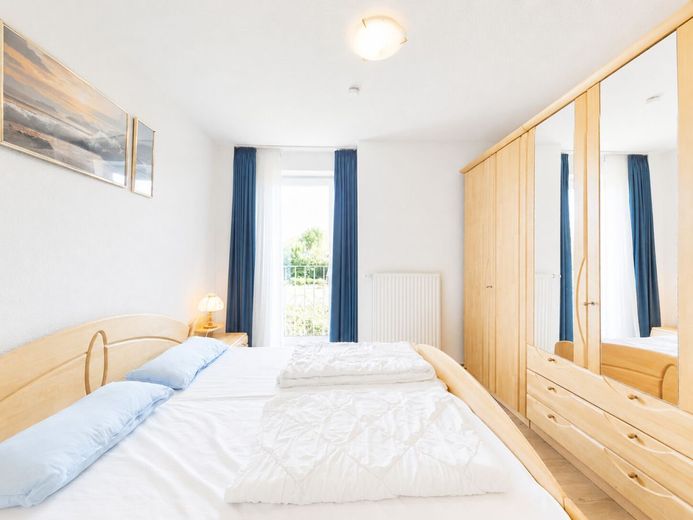 Urlaub beginnt hier - helle Ferien-Wohnung mit 
Balkon &amp; Sauna an der Nordsee in Dorum-Neufeld – Freundliches Schlafzimmer für erholsame Nächte