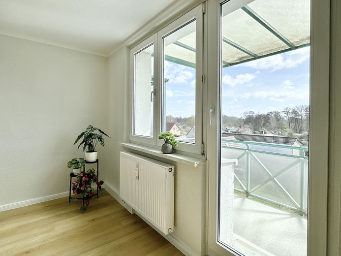 Vermietete 3-Zimmer-Wohnung mit Einbauküche und Südbalkon – Kapitalanlage in Bützow – Wohnzimmer mit Balkon
