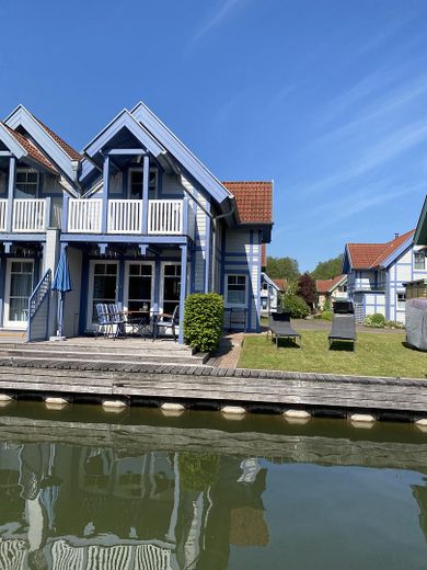 Ferienhaus mit eigenem Bootssteg im Hafendorf Rheinsberg – Ansicht vom Wasser