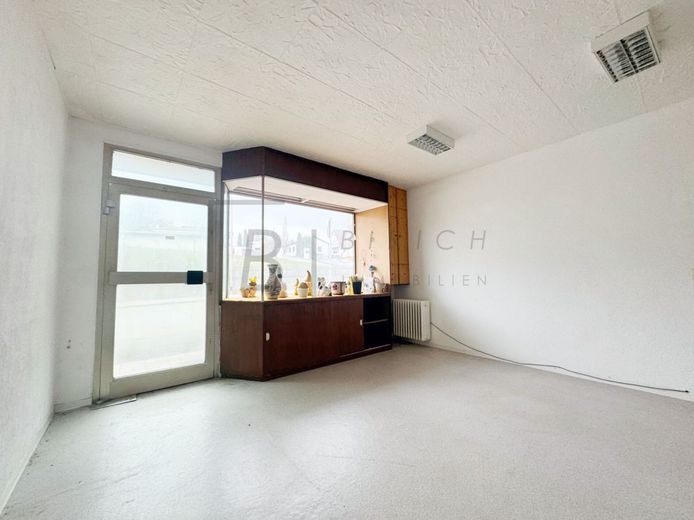 Großzügige 4-Zimmer-EG-Wohnung mit Balkon, Garage und attraktivem Entwicklungspotenzial – Laden