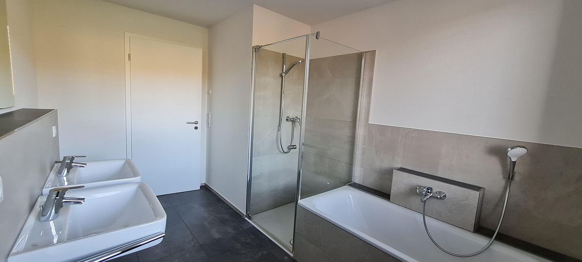 1. piętro nowoczesne mieszkanie 3,5-pokojowe z windą, zabudowaną kuchnią, zadaszonym balkonem, pomieszczeniem gospodarczym i WC dla gości – Bad