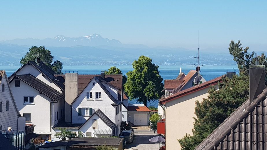 4-Zimmerwohnung in Traumlage mit Kachelofen, Balkon, Dachterrasse, Gästebad und Garage – Blick vom Haus auf den See