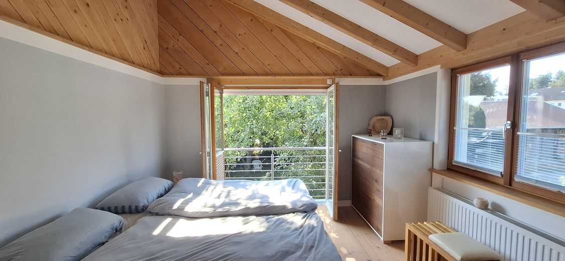 Arrivare. Respirare. Sentirsi a casa. Casa d'architetto in costruzione ecologica in legno – OG Eltern Schlafzimmer Falttür