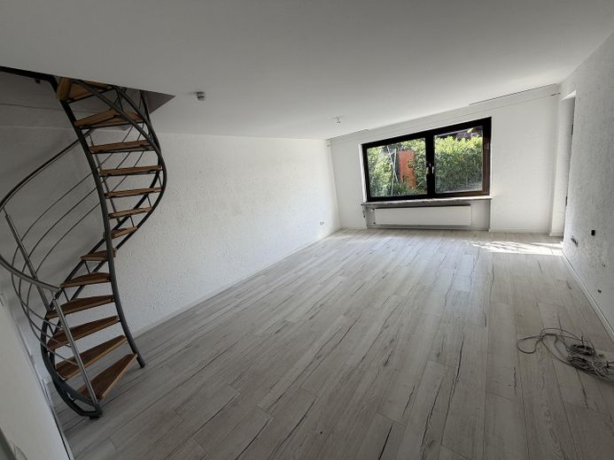 Huzurun şehre yakınlıkla buluştuğu yer – güneş alan güney bahçesiyle – Wohnzimmer mit Wendeltreppe zu