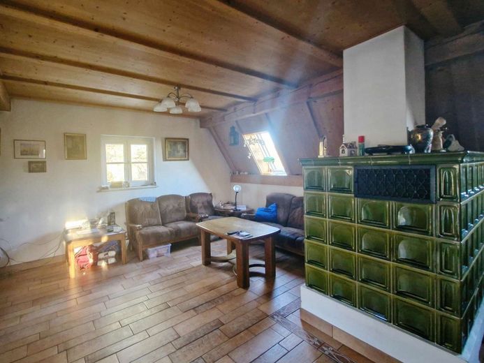 Wohnen im eigenen 1,8‑Hektar‑Wald – gemütlicher Wohnbereich mit Kachelofen im OG