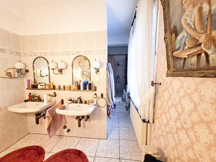 Badezimmer mit Doppelwaschbecken, WC, Dusche und Badewanne