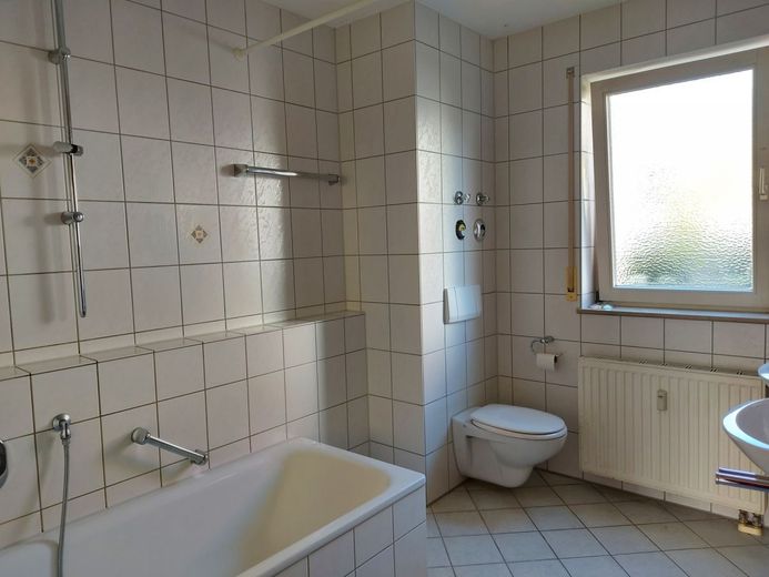 Badezimmer mit Badewanne, WC und zwei Waschbecken