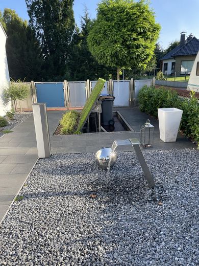 Zaun, Mülltonnen, Wasserspiel