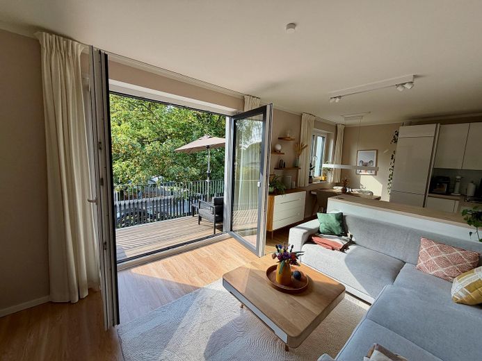 Sin comisión: Moderno apartamento de 4 habitaciones con balcón orientado al oeste y plaza de garaje subterránea con posibilidad de carga – Wohnzimmer