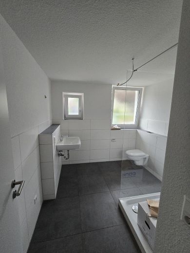 Moderno appartamento di 2,5 locali al piano terra, conforme allo standard KfW-55-EE – efficiente dal punto di vista energetico e dotato di finiture di pregio – Bad