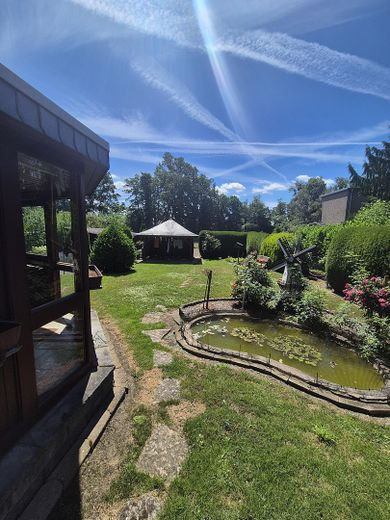 Charmantes Einfamilienhaus mit traumhaftem Südgarten, Wintergarten und Doppelgarage – Garten mit Teich