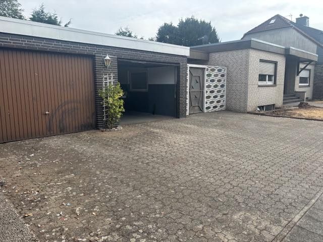 Bungalow mit großer Doppelgarage in ruhiger, zentraler Lage auf tollem Grundstück – Doppelgarage und Eingang zum G
